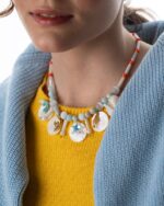 A handcrafted Seashell Serenity Necklace featuring seashells, mother-of-pearl, Swarovski crystals, and gold-plated charms.