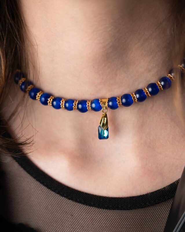 A handcrafted Egypt-Inspired Dark Blue Necklace featuring cat’s eye stones, Swarovski crystals, and black accents.